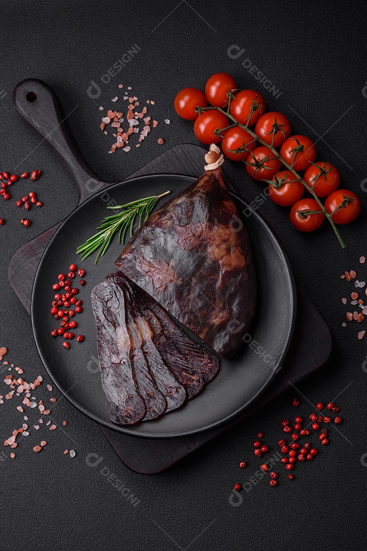 Deliciosa salsicha de carne de cavalo mahan fumada ou curada com especiarias e ervas sobre um fundo escuro de concreto