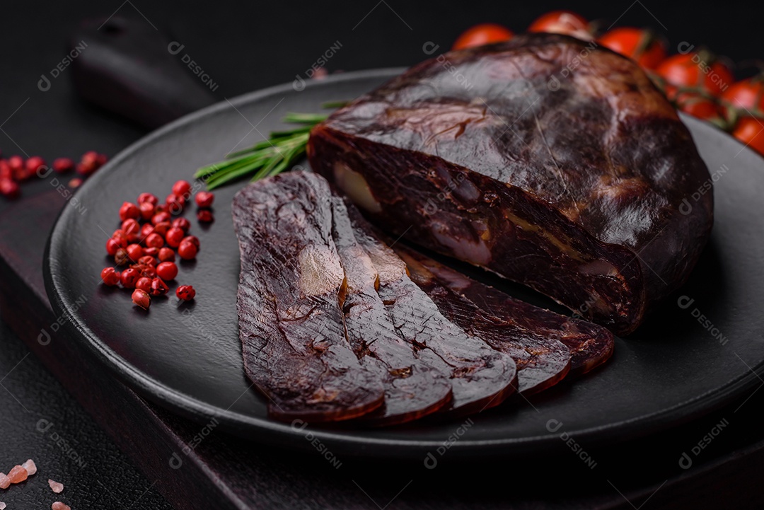 Deliciosa salsicha de carne de cavalo mahan fumada ou curada com especiarias e ervas sobre um fundo escuro de concreto