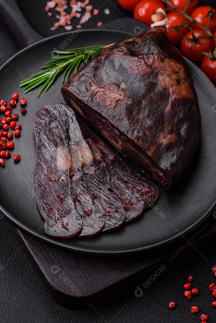 Deliciosa salsicha de carne de cavalo mahan fumada ou curada com especiarias e ervas sobre um fundo escuro de concreto