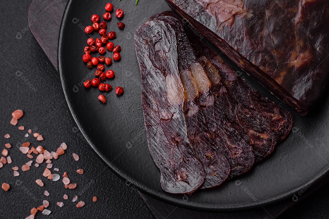Deliciosa salsicha de carne de cavalo mahan fumada ou curada com especiarias e ervas sobre um fundo escuro de concreto
