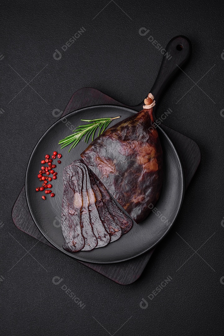 Deliciosa salsicha de carne de cavalo mahan fumada ou curada com especiarias e ervas sobre um fundo escuro de concreto