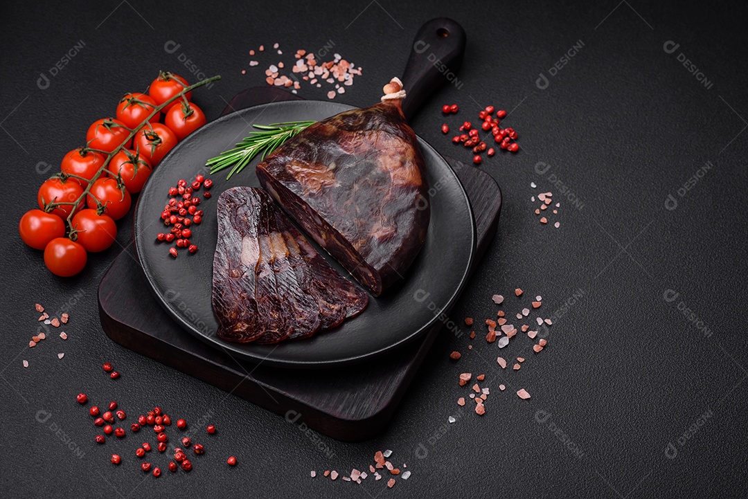 Deliciosa salsicha de carne de cavalo mahan fumada ou curada com especiarias e ervas sobre um fundo escuro de concreto