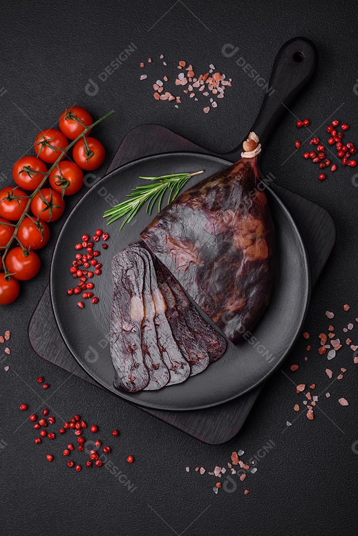 Deliciosa salsicha de carne de cavalo mahan fumada ou curada com especiarias e ervas sobre um fundo escuro de concreto