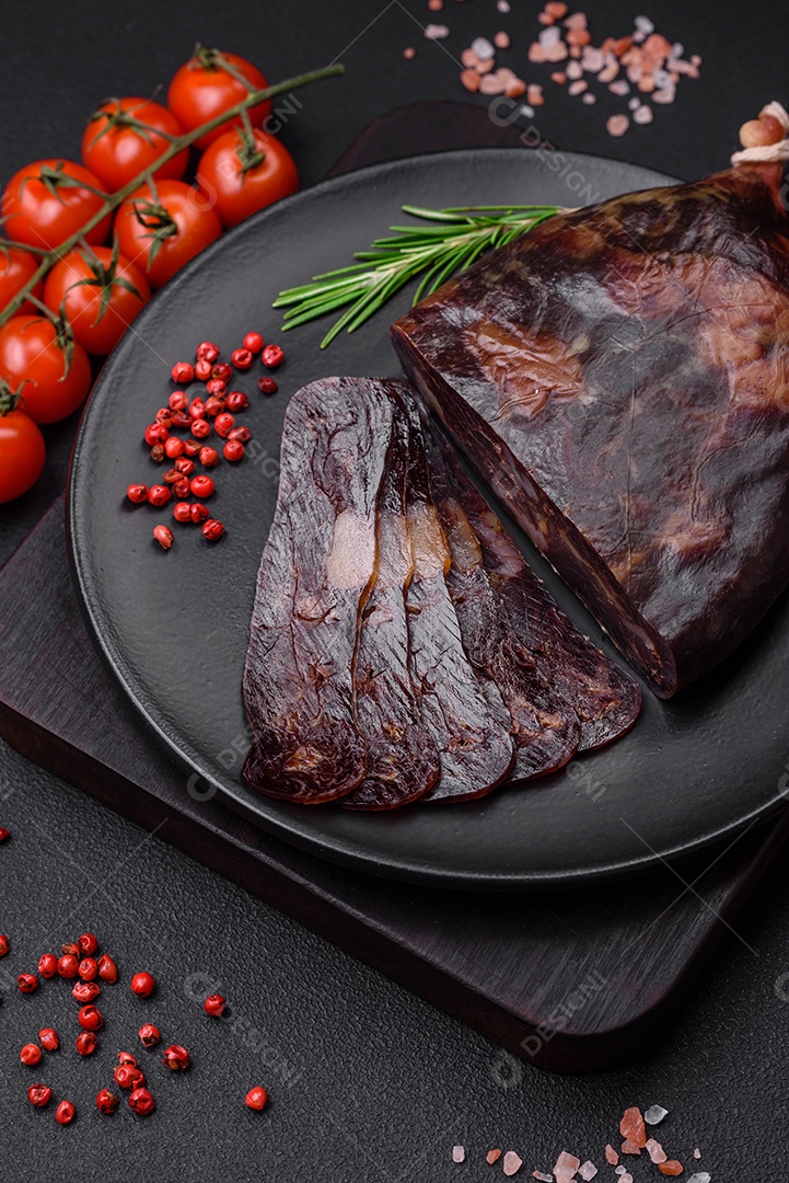 Deliciosa salsicha de carne de cavalo mahan fumada ou curada com especiarias e ervas sobre um fundo escuro de concreto