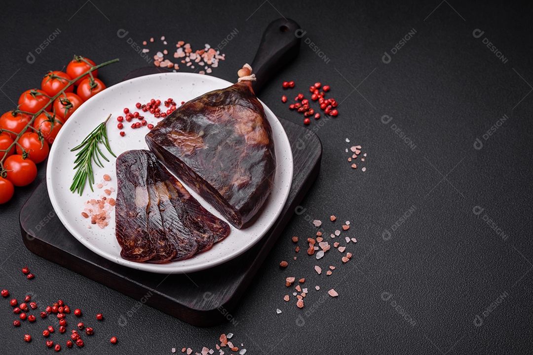 Deliciosa salsicha de carne de cavalo mahan fumada ou curada com especiarias e ervas sobre um fundo escuro de concreto