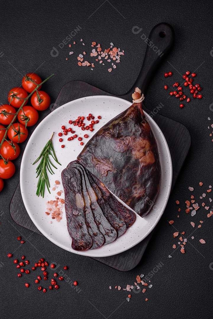 Deliciosa salsicha de carne de cavalo mahan fumada ou curada com especiarias e ervas sobre um fundo escuro de concreto