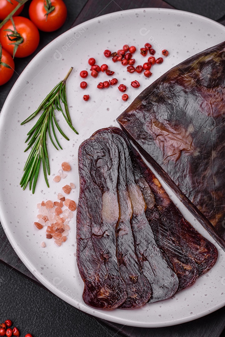 Deliciosa salsicha de carne de cavalo mahan fumada ou curada com especiarias e ervas sobre um fundo escuro de concreto