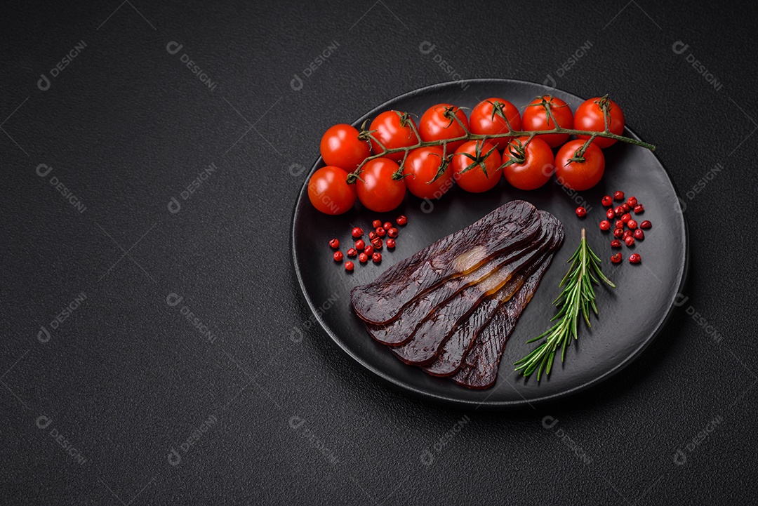 Deliciosa salsicha de carne de cavalo mahan fumada ou curada com especiarias e ervas sobre um fundo escuro de concreto