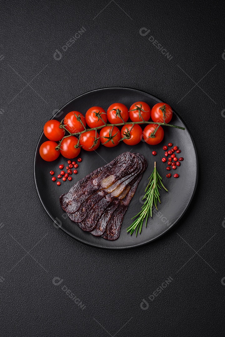 Deliciosa salsicha de carne de cavalo mahan fumada ou curada com especiarias e ervas sobre um fundo escuro de concreto