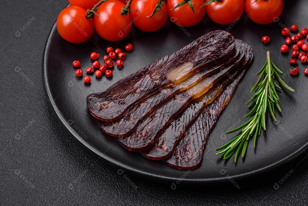 Deliciosa salsicha de carne de cavalo mahan fumada ou curada com especiarias e ervas sobre um fundo escuro de concreto