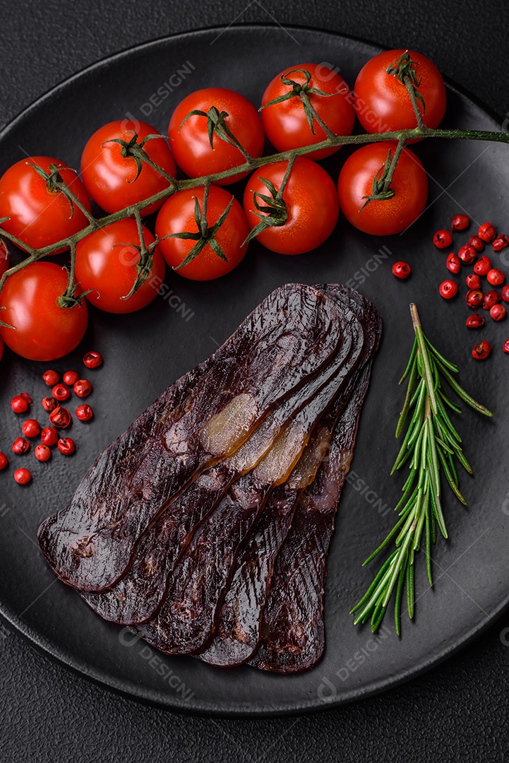 Deliciosa salsicha de carne de cavalo mahan fumada ou curada com especiarias e ervas sobre um fundo escuro de concreto