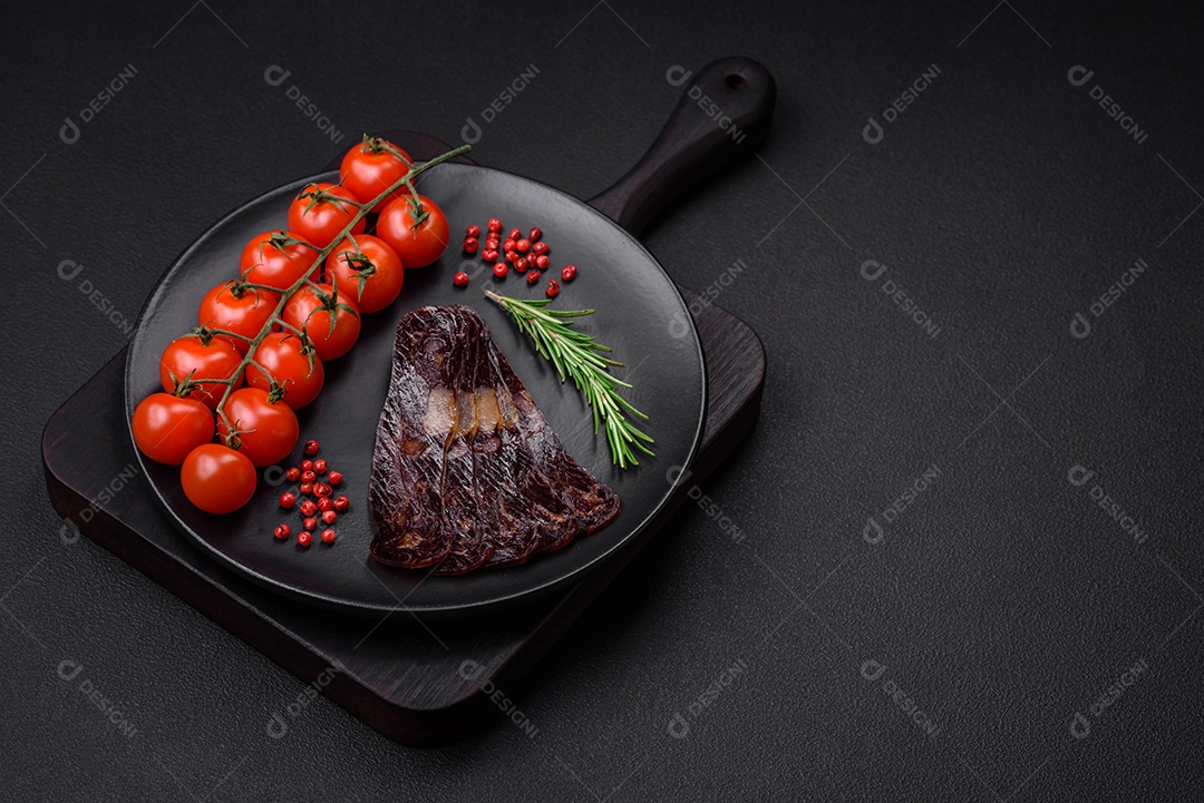 Deliciosa salsicha de carne de cavalo mahan fumada ou curada com especiarias e ervas sobre um fundo escuro de concreto