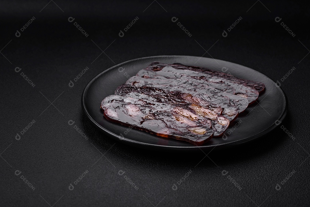 Deliciosa salsicha de carne de cavalo mahan fumada ou curada com especiarias e ervas sobre um fundo escuro de concreto