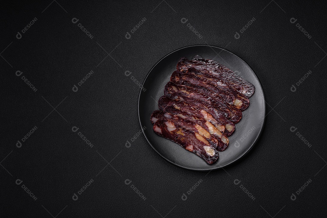 Deliciosa salsicha de carne de cavalo mahan fumada ou curada com especiarias e ervas sobre um fundo escuro de concreto