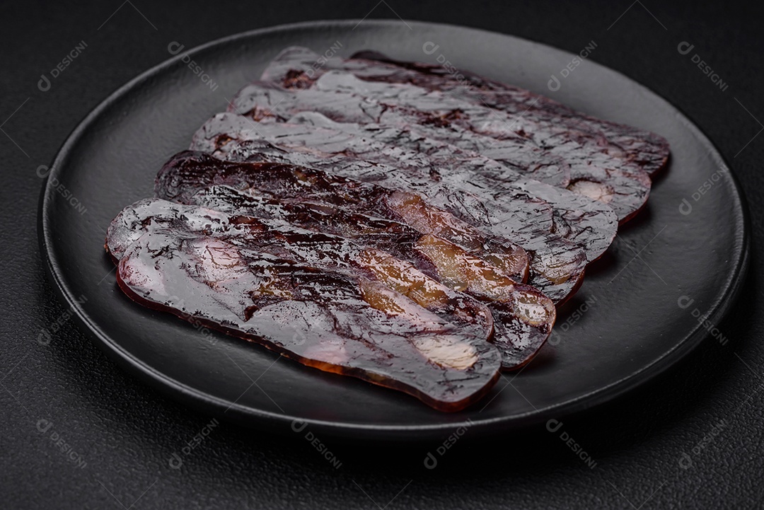 Deliciosa salsicha de carne de cavalo mahan fumada ou curada com especiarias e ervas sobre um fundo escuro de concreto