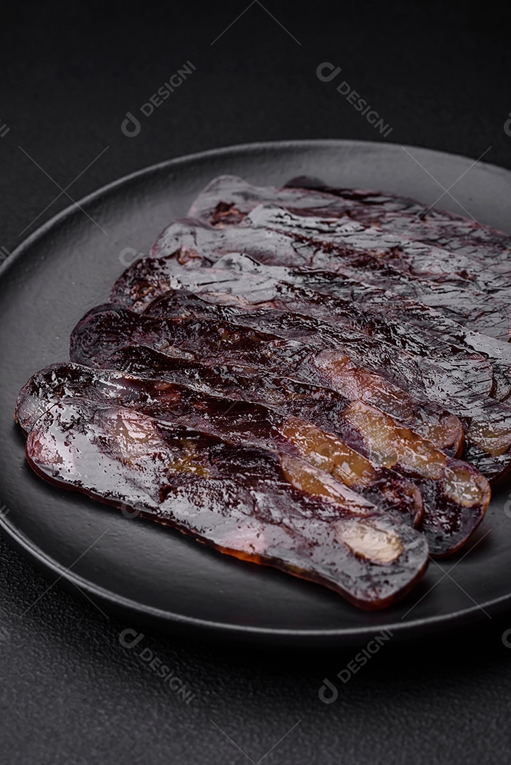 Deliciosa salsicha de carne de cavalo mahan fumada ou curada com especiarias e ervas sobre um fundo escuro de concreto