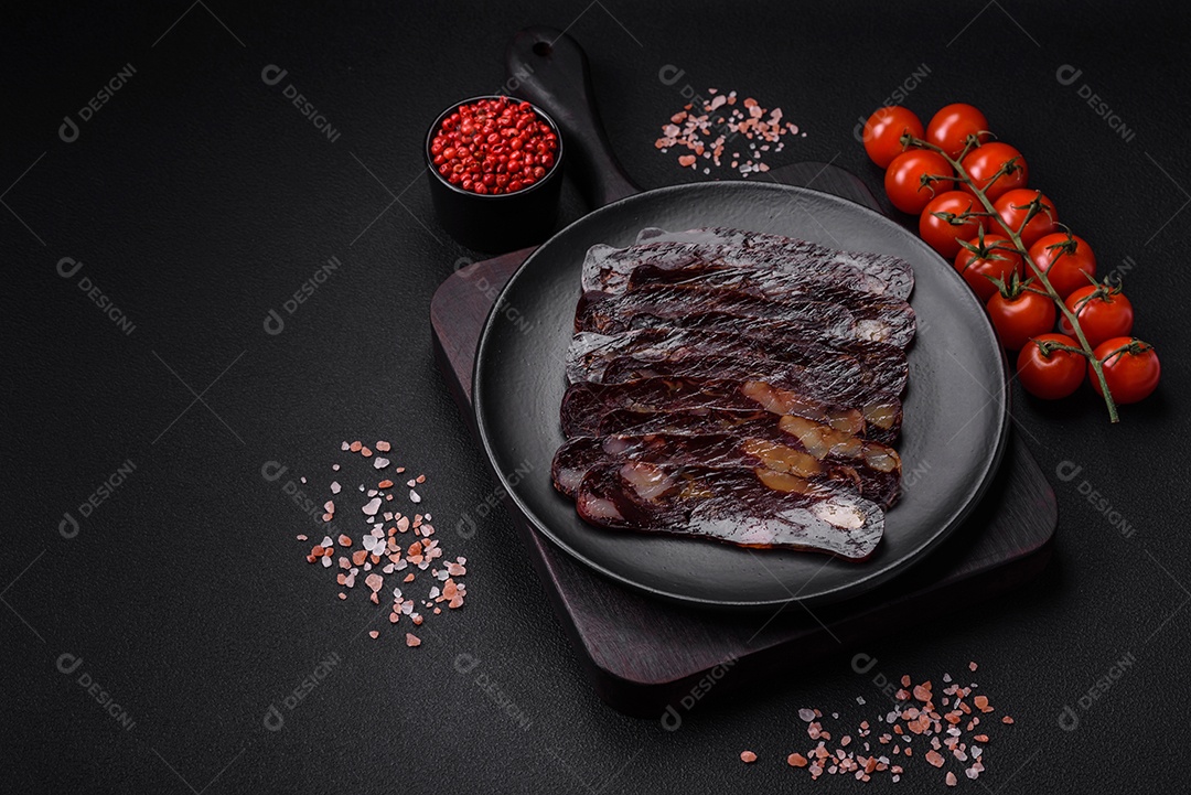 Deliciosa salsicha de carne de cavalo mahan fumada ou curada com especiarias e ervas sobre um fundo escuro de concreto