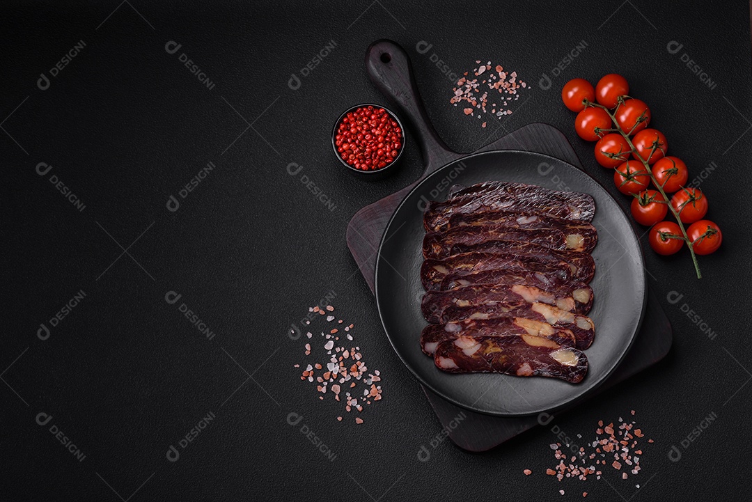 Deliciosa salsicha de carne de cavalo mahan fumada ou curada com especiarias e ervas sobre um fundo escuro de concreto