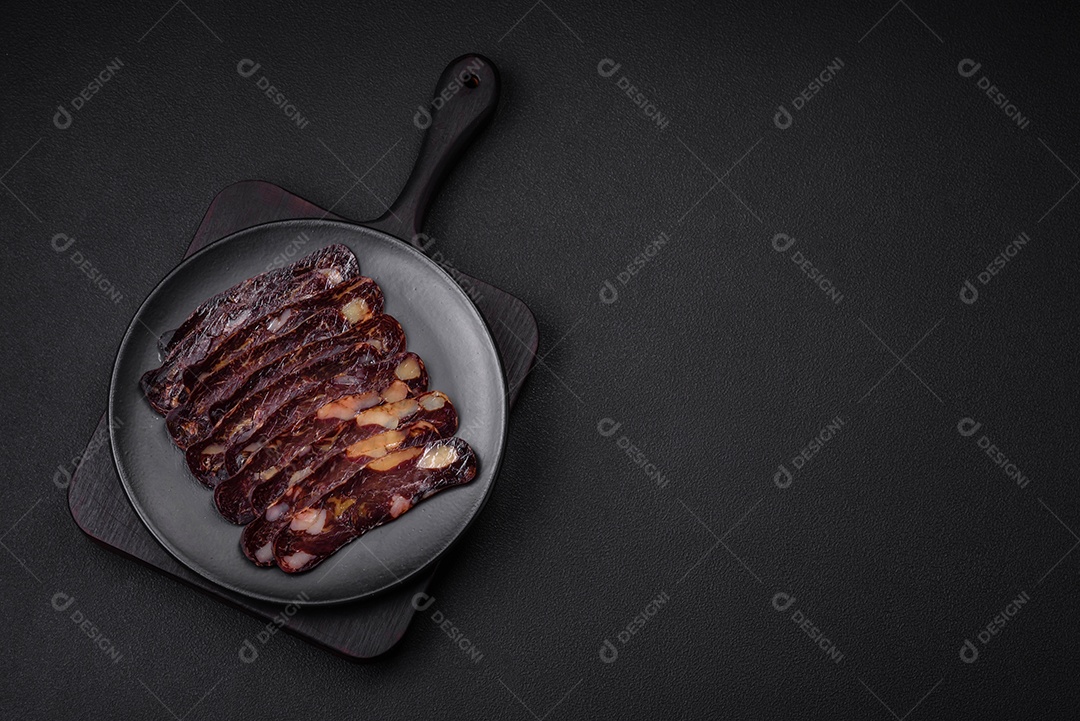 Deliciosa salsicha de carne de cavalo mahan fumada ou curada com especiarias e ervas sobre um fundo escuro de concreto