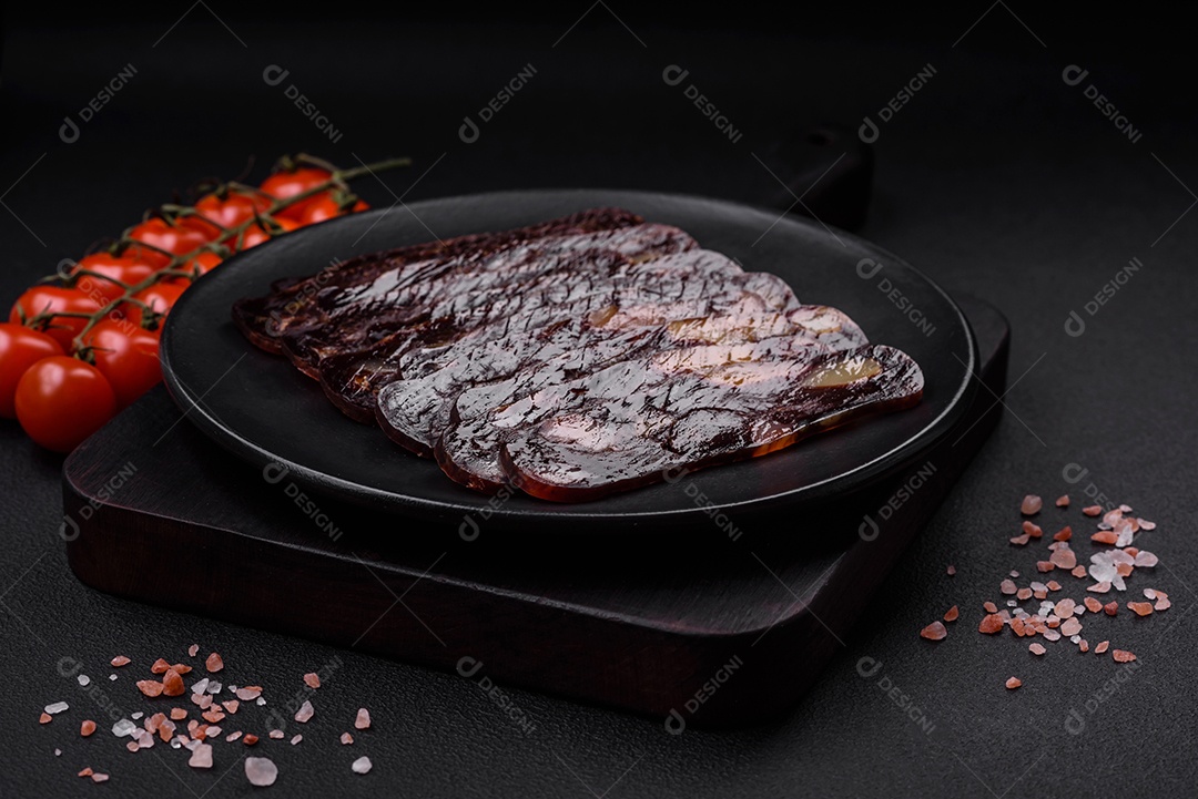 Deliciosa salsicha de carne de cavalo mahan fumada ou curada com especiarias e ervas sobre um fundo escuro de concreto