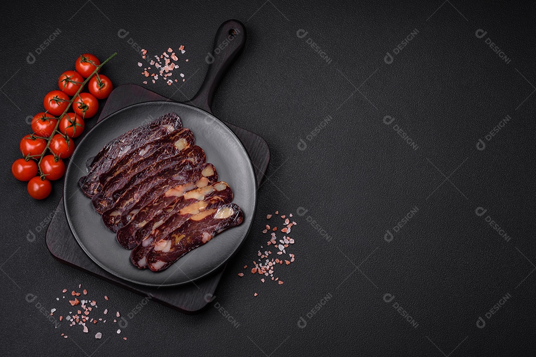 Deliciosa salsicha de carne de cavalo mahan fumada ou curada com especiarias e ervas sobre um fundo escuro de concreto