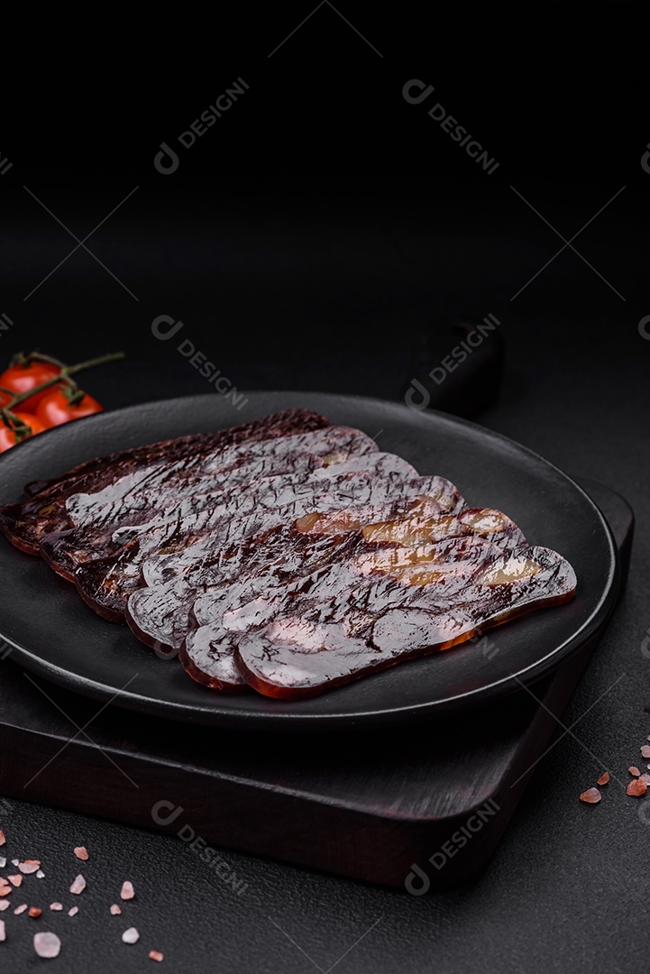 Deliciosa salsicha de carne de cavalo mahan fumada ou curada com especiarias e ervas sobre um fundo escuro de concreto