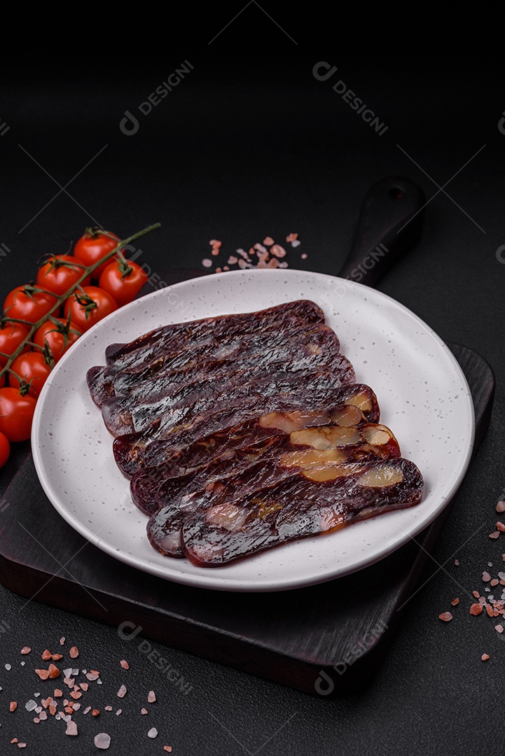 Deliciosa salsicha de carne de cavalo mahan fumada ou curada com especiarias e ervas sobre um fundo escuro de concreto