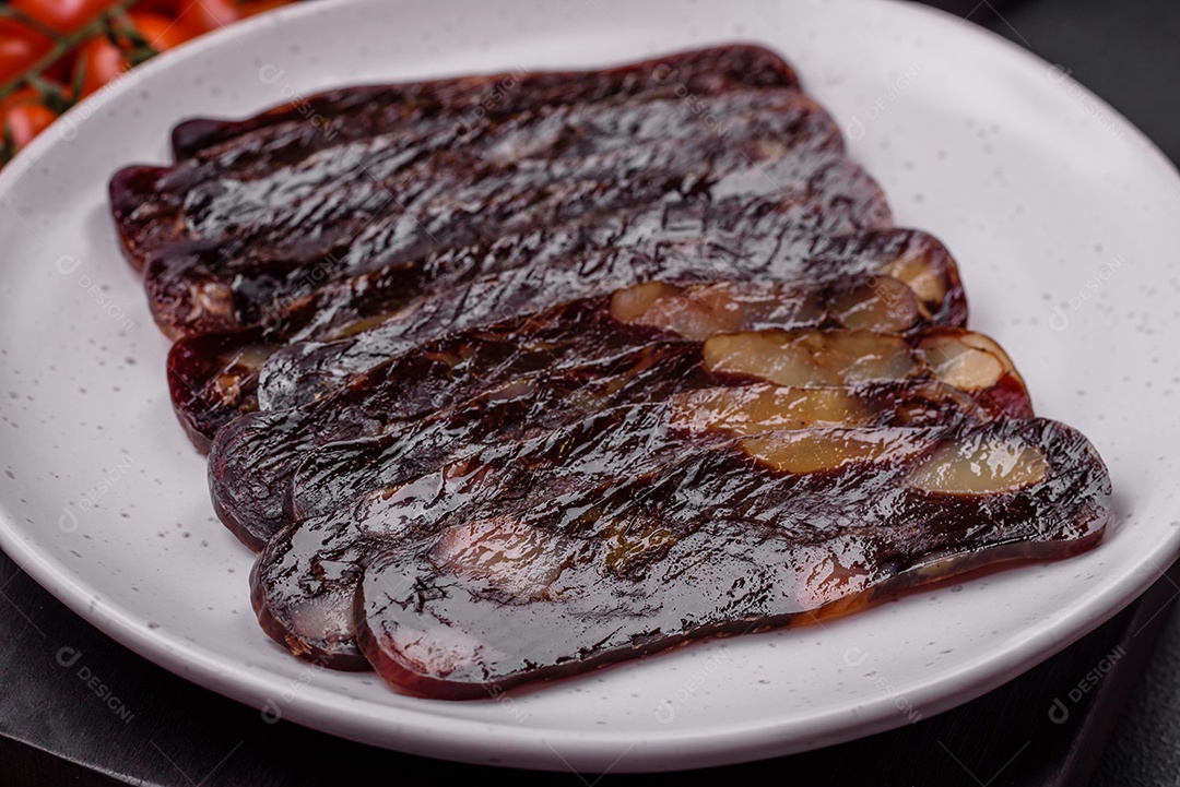 Deliciosa salsicha de carne de cavalo mahan fumada ou curada com especiarias e ervas sobre um fundo escuro de concreto