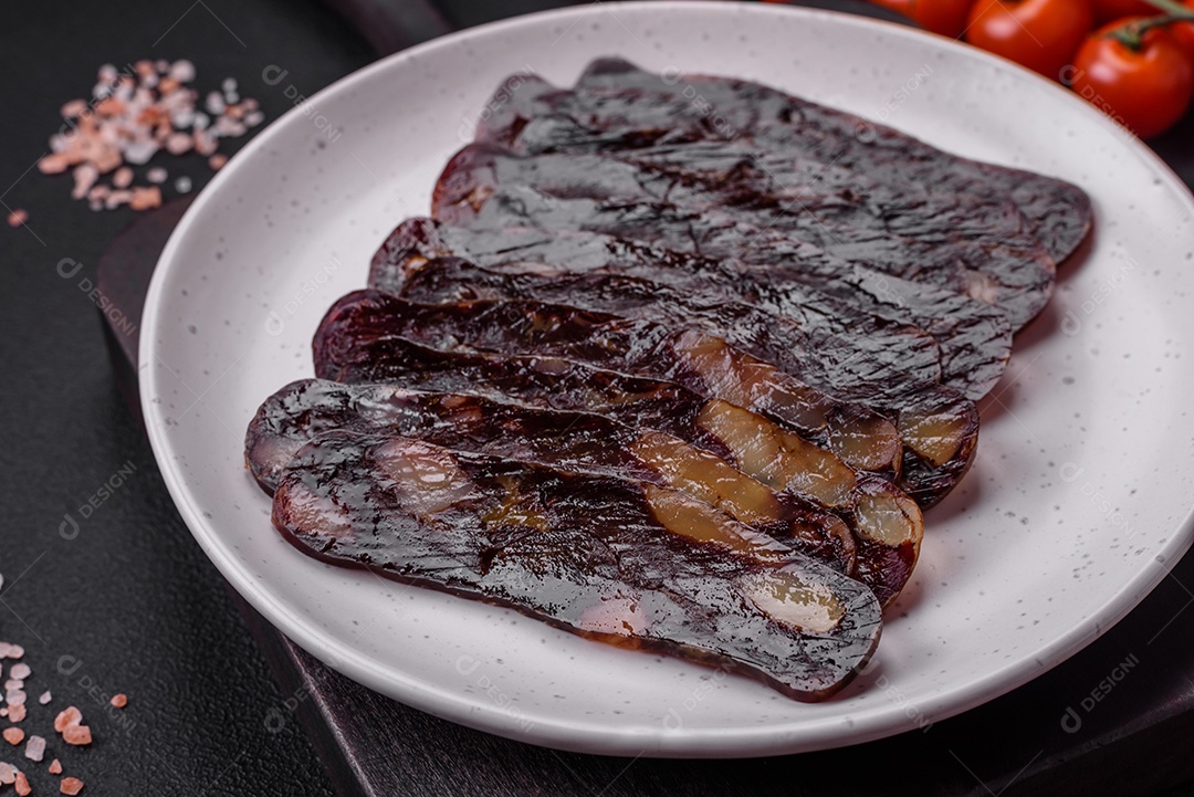 Deliciosa salsicha de carne de cavalo mahan fumada ou curada com especiarias e ervas sobre um fundo escuro de concreto