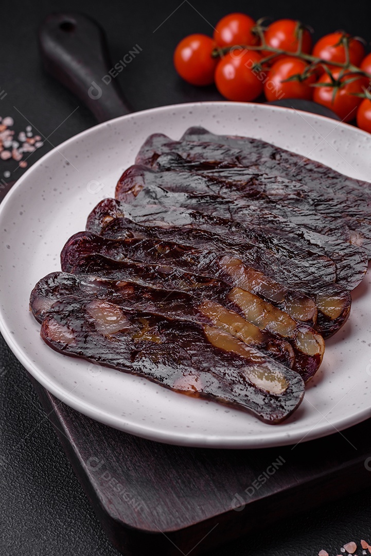 Deliciosa salsicha de carne de cavalo mahan fumada ou curada com especiarias e ervas sobre um fundo escuro de concreto