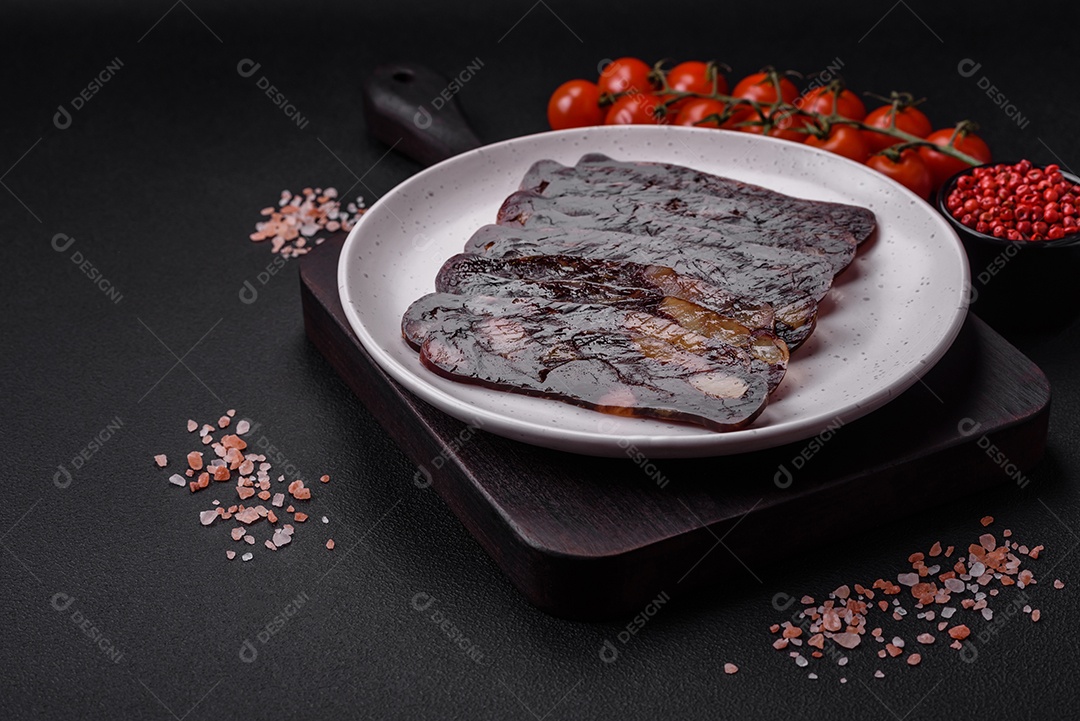 Deliciosa salsicha de carne de cavalo mahan fumada ou curada com especiarias e ervas sobre um fundo escuro de concreto