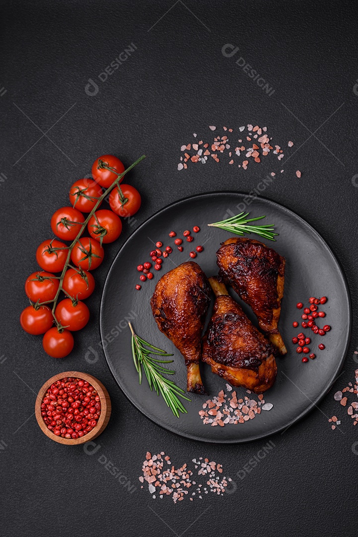 Deliciosas pernas de frango grelhado com especiarias e ervas em molho teriyaki sobre um fundo escuro de concreto