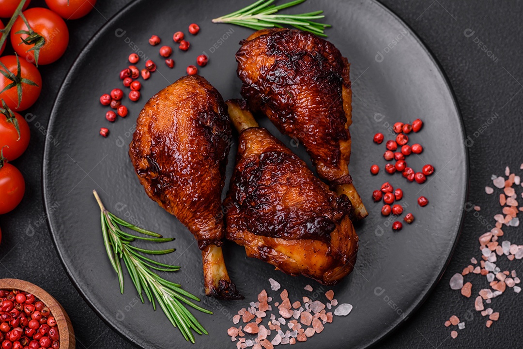 Deliciosas pernas de frango grelhado com especiarias e ervas em molho teriyaki sobre um fundo escuro de concreto