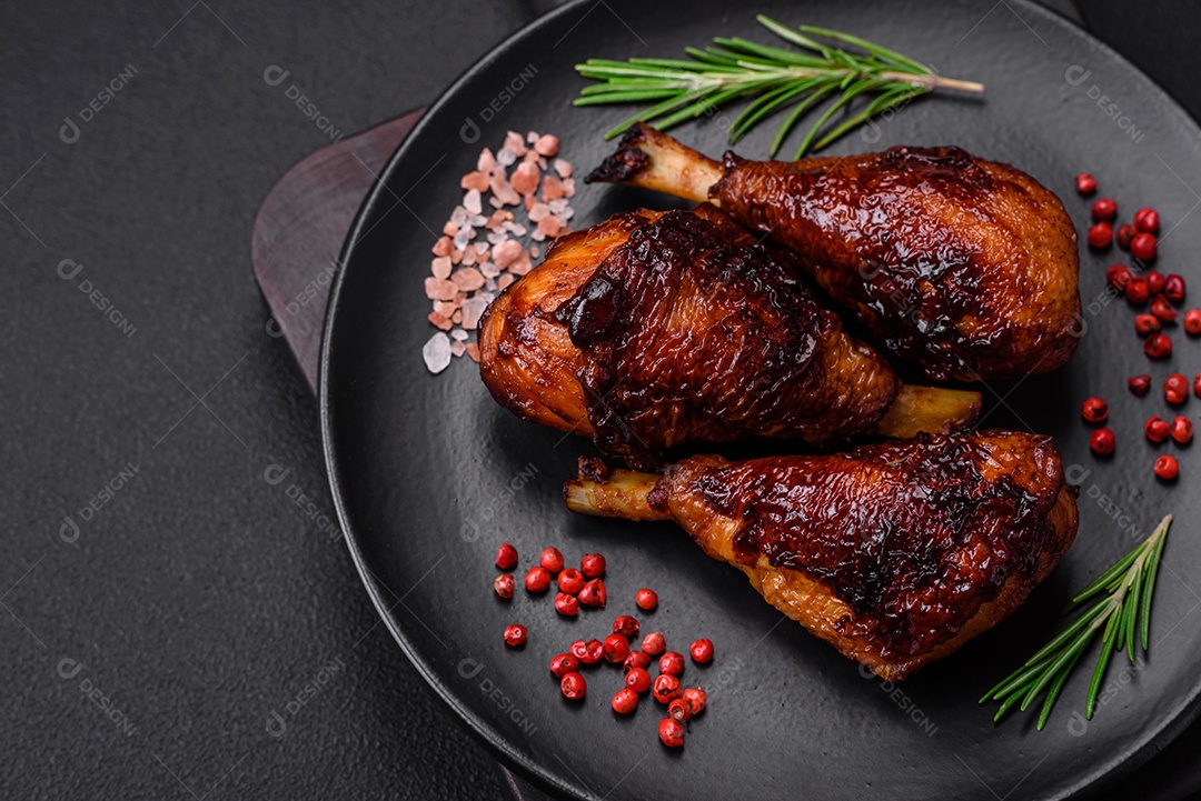 Deliciosas pernas de frango grelhado com especiarias e ervas em molho teriyaki sobre um fundo escuro de concreto