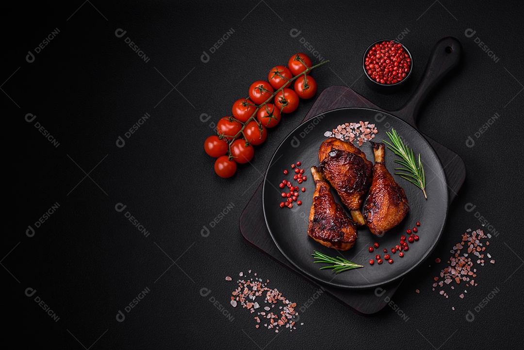 Deliciosas pernas de frango grelhado com especiarias e ervas em molho teriyaki sobre um fundo escuro de concreto