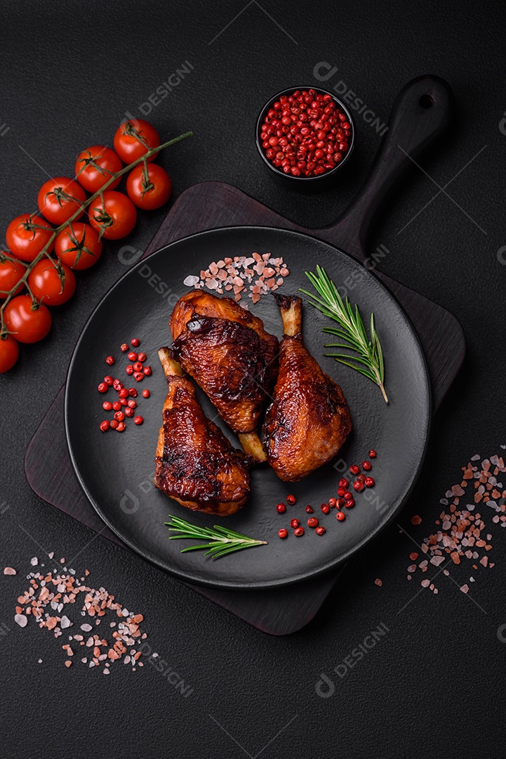 Deliciosas pernas de frango grelhado com especiarias e ervas em molho teriyaki sobre um fundo escuro de concreto