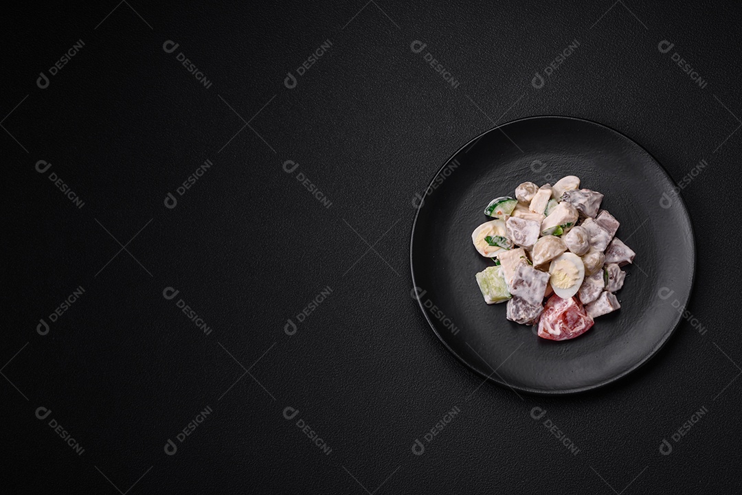 Deliciosa salada com língua de boi cozida, ovos de codorna, tomate e pepino sobre um fundo escuro de concreto