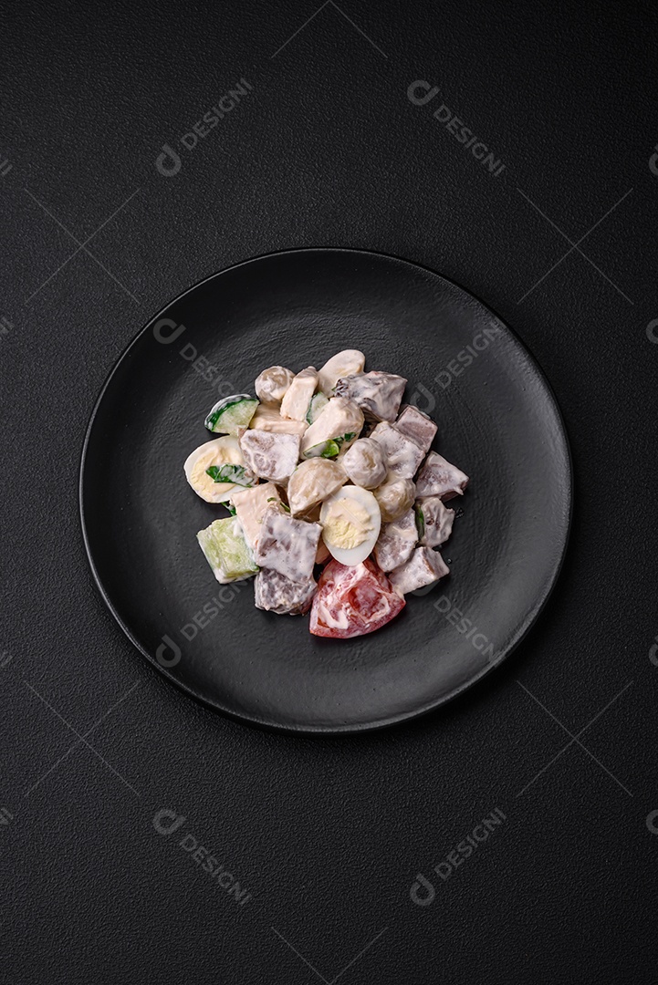 Deliciosa salada com língua de boi cozida, ovos de codorna, tomate e pepino sobre um fundo escuro de concreto