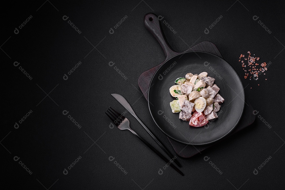 Deliciosa salada com língua de boi cozida, ovos de codorna, tomate e pepino sobre um fundo escuro de concreto