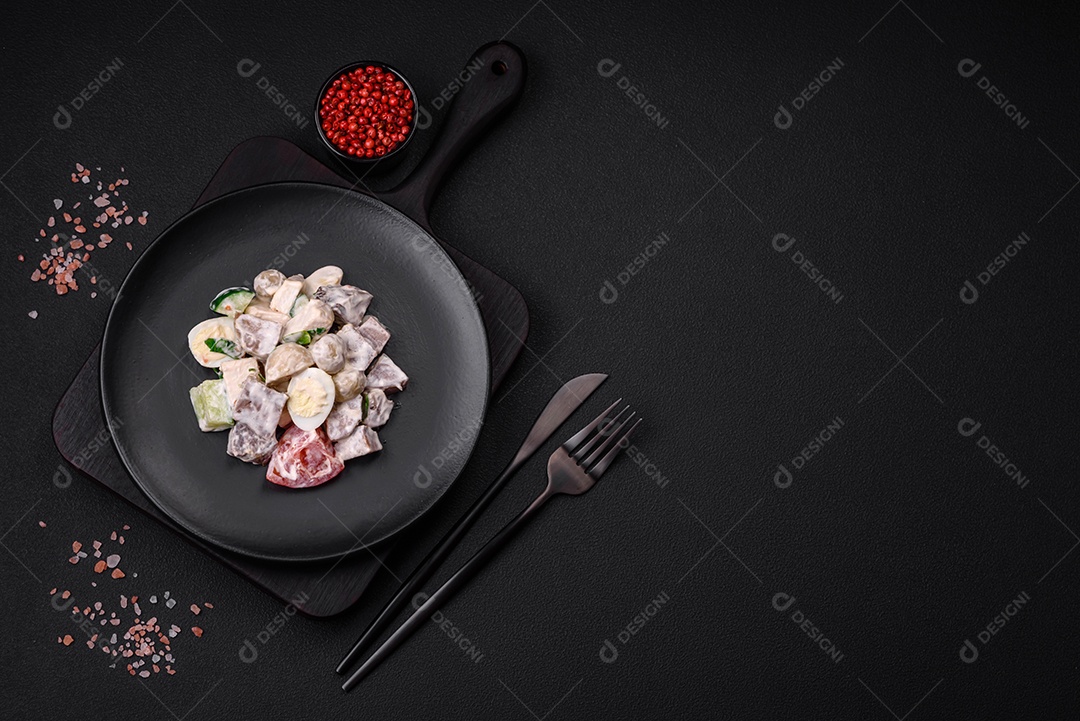 Deliciosa salada com língua de boi cozida, ovos de codorna, tomate e pepino sobre um fundo escuro de concreto