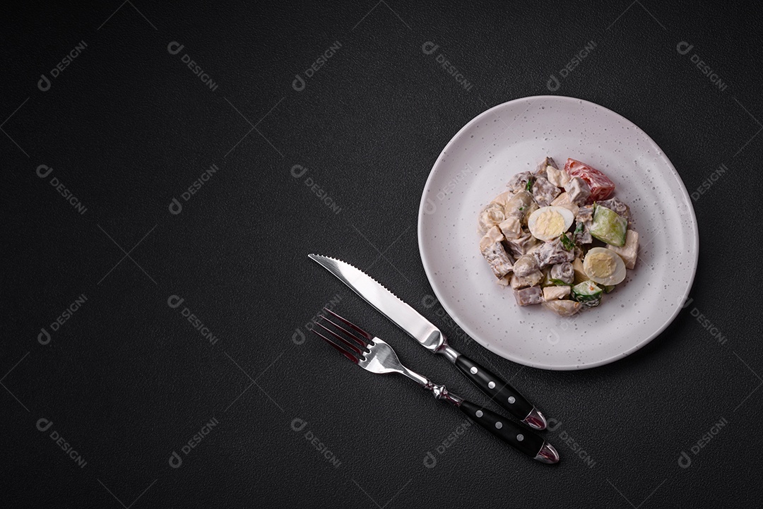 Deliciosa salada com língua de boi cozida, ovos de codorna, tomate e pepino sobre um fundo escuro de concreto