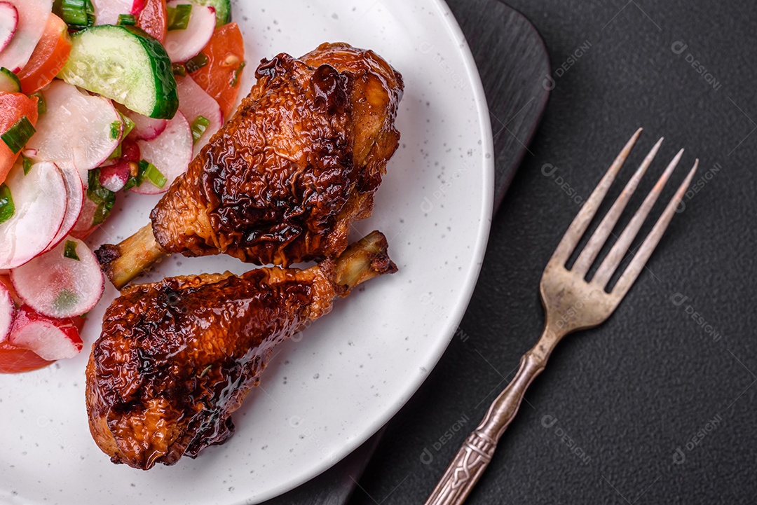 Deliciosa salada vegana de legumes frescos de tomate, pepino e rabanete com sal e especiarias sobre um fundo escuro de concreto