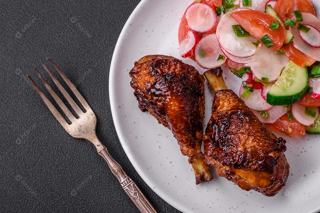 Deliciosa salada vegana de legumes frescos de tomate, pepino e rabanete com sal e especiarias sobre um fundo escuro de concreto