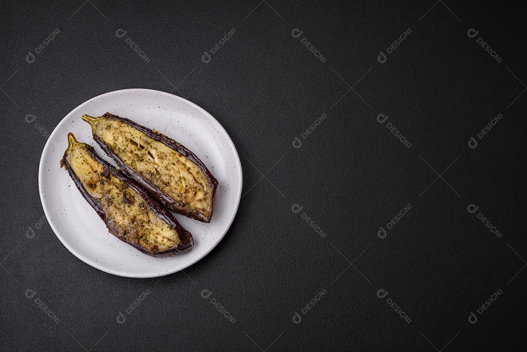 Deliciosa abobrinha cortada em duas metades assada com sal, especiarias e ervas sobre um fundo escuro de concreto