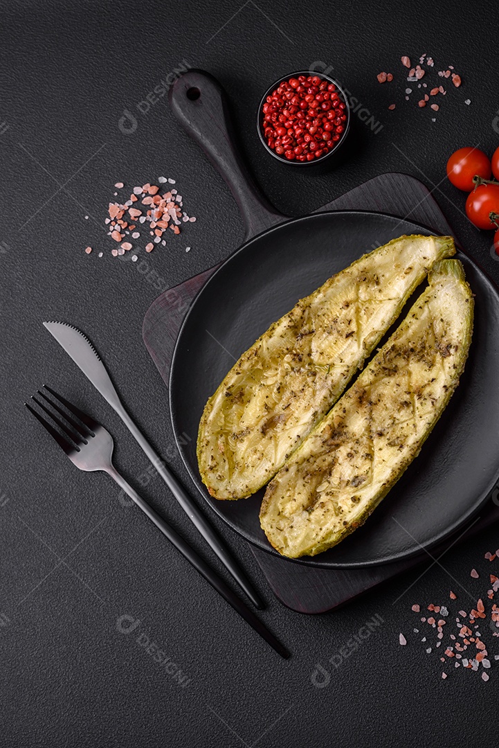 Deliciosa abobrinha cortada em duas metades assada com sal, especiarias e ervas sobre um fundo escuro de concreto