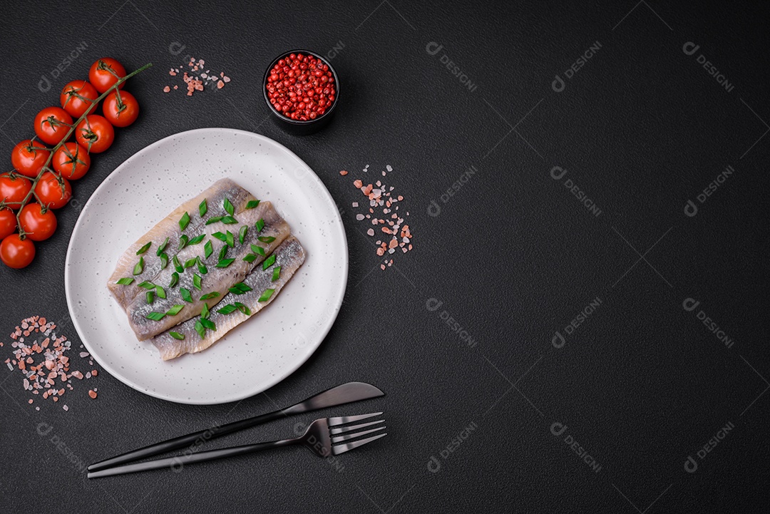 Delicioso arenque do Atlântico marinado com sal e especiarias em óleo sobre um fundo escuro de concreto