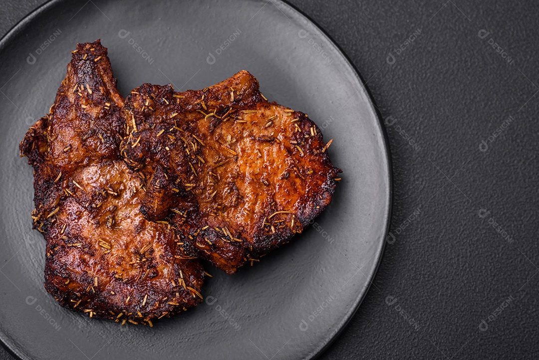 Deliciosas pernas de frango grelhado com especiarias e ervas em molho teriyaki sobre um fundo escuro de concreto