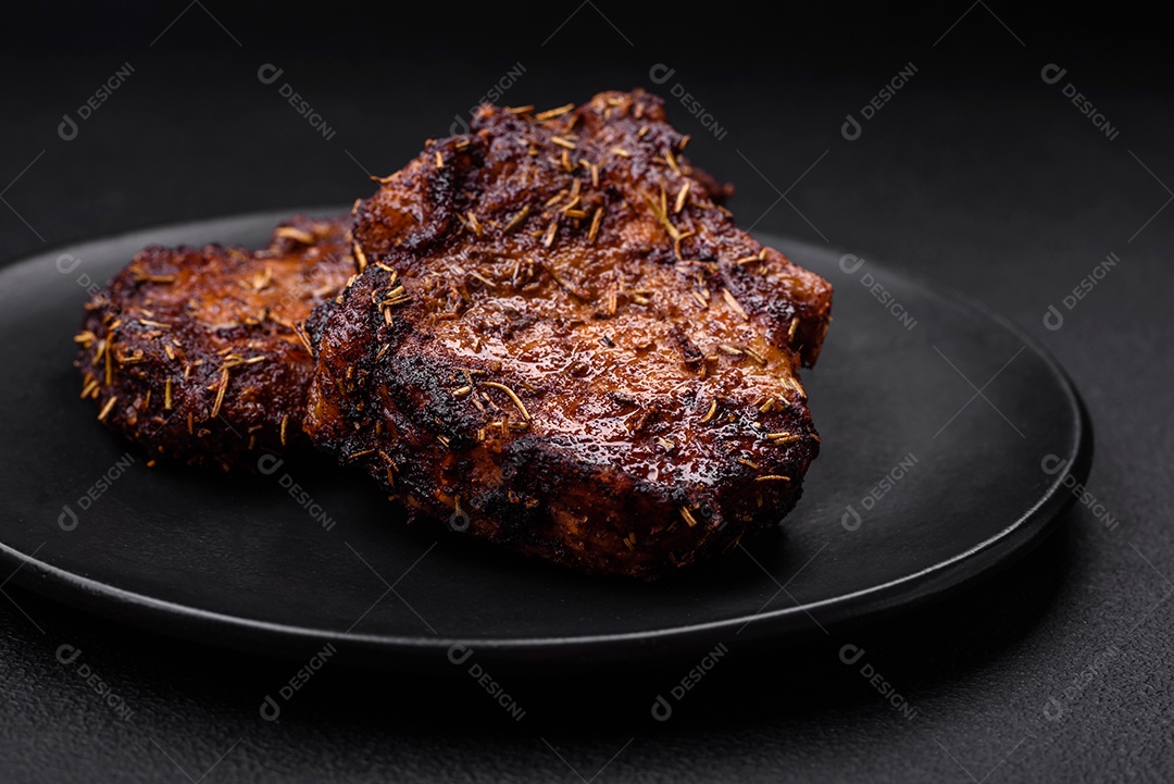 Deliciosas pernas de frango grelhado com especiarias e ervas em molho teriyaki sobre um fundo escuro de concreto