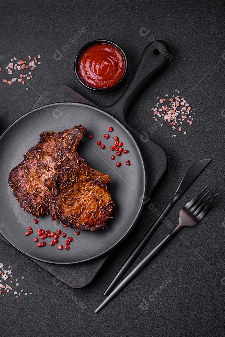 Deliciosas pernas de frango grelhado com especiarias e ervas em molho teriyaki sobre um fundo escuro de concreto