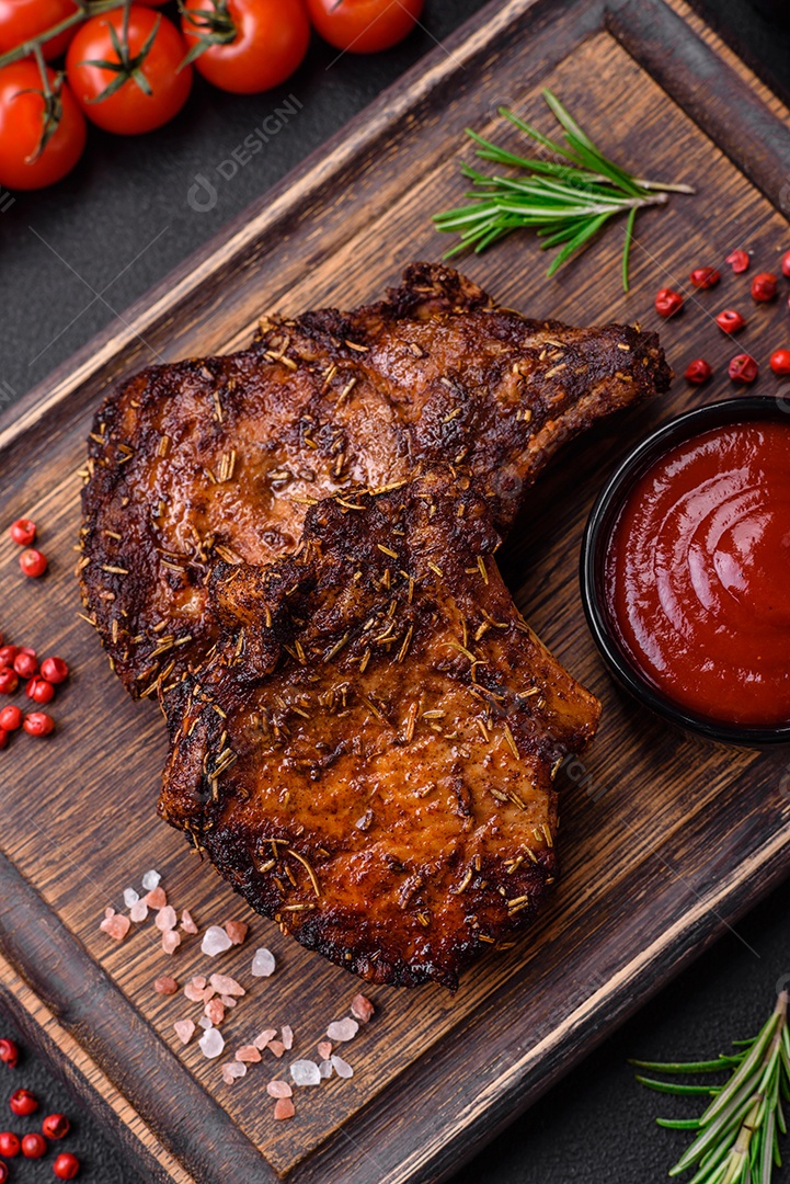 Deliciosas pernas de frango grelhado com especiarias e ervas em molho teriyaki sobre um fundo escuro de concreto